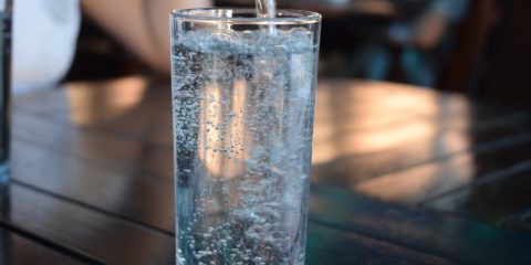 Mineralwasser wird in ein Glas eingegossen.