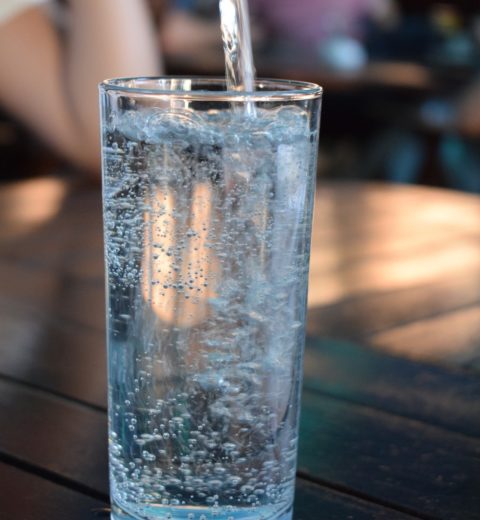 Mineralwasser wird in ein Glas eingegossen.
