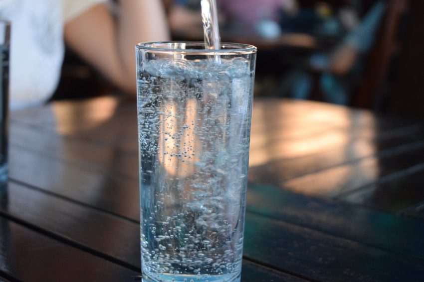 Mineralwasser wird in ein Glas eingegossen.